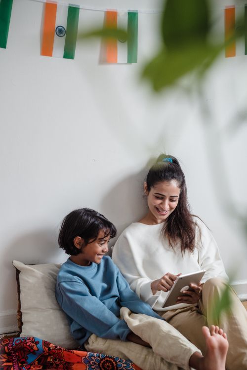 Free A joyful moment between mother and child using a digital tablet indoors, surrounded by home decor. Stock Photo