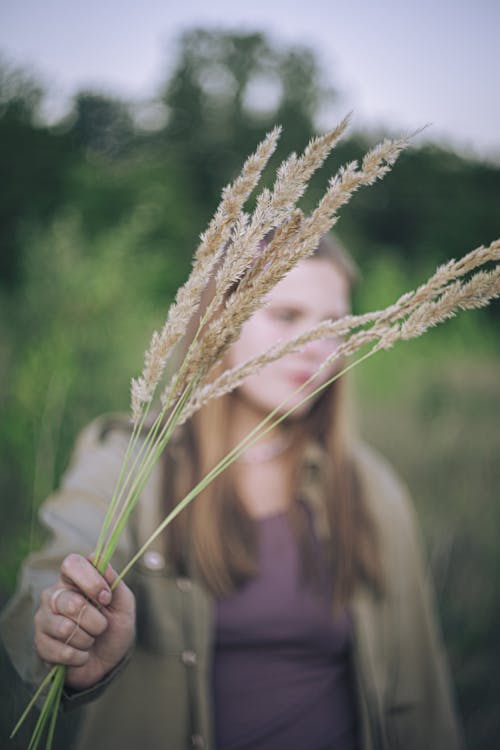 Woman Holding Bunch of Grass