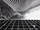 低角度拍摄的现代摩天大楼与引人注目的云层相映衬，展现了未来主义的城市设计