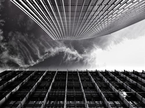 Free A striking low-angle view of modern skyscrapers against dramatic clouds, showcasing futuristic urban design. Stock Photo
