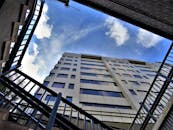 戏剧性的低角度镜头中，一座现代摩天大楼被蓝天和云层环绕