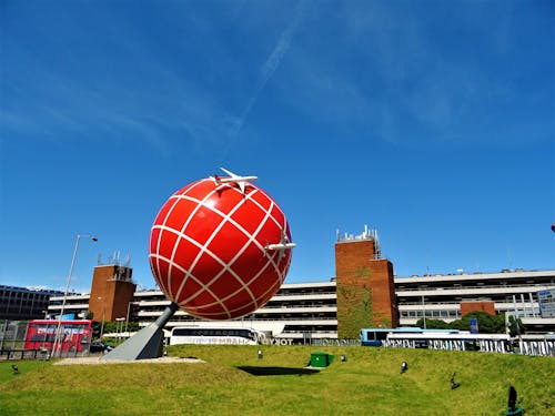 갈색과 흰색 콘크리트 건물 근처 빨간색과 흰색 지구본 동상