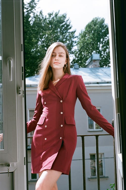 A Woman Posing while Leaning on the Metal Railing