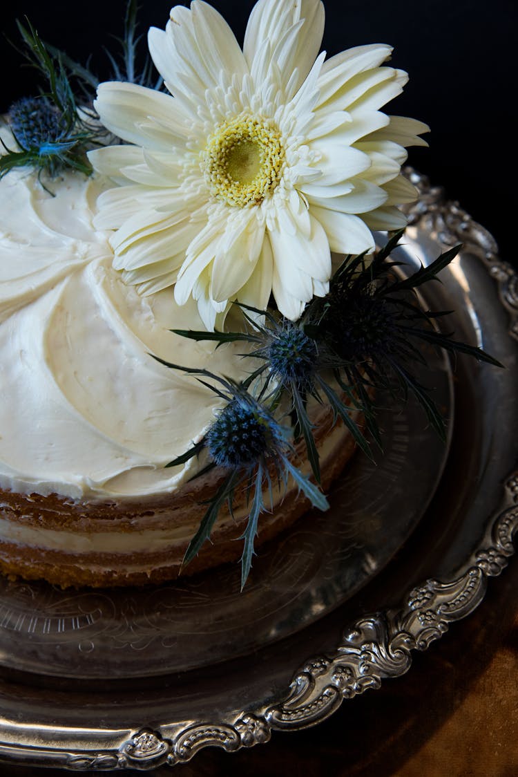 White Flowers On Round Cake With White Cream