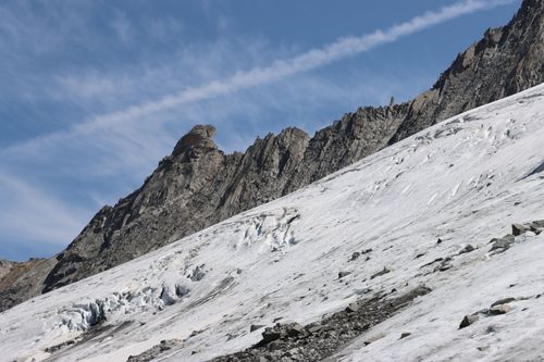 Free A scenic view of a rugged, snow-covered mountain slope under a clear blue sky. Stock Photo