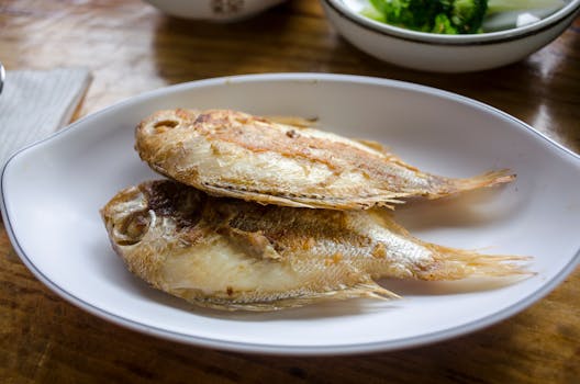 A plate of crispy fried fish served on a dining table, ready for meal time.