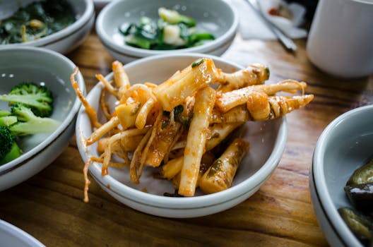 Close-up of assorted Korean side dishes, showcasing vibrant traditional flavors on a wooden table.