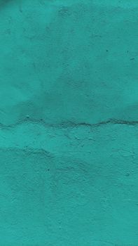 A close-up of a turquoise concrete wall showcasing rough texture and minimalist design.