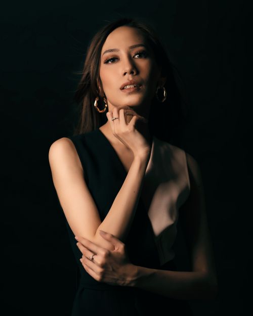 Free Stylish portrait of a woman posing with thoughtful elegance against a dark background. Stock Photo