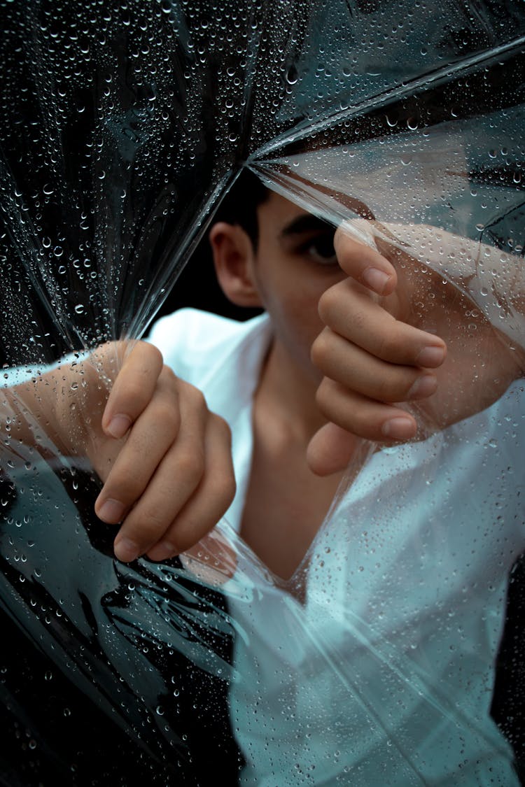 A Man Tearing Apart A Wet Plastic