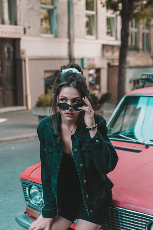 A Woman Posing in Front of a Car