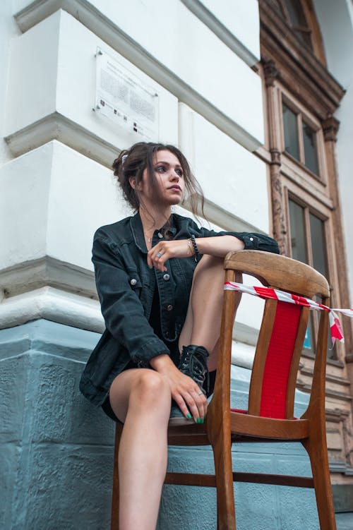 Low Angle Shot of Woman seated on a Wooden Chair 