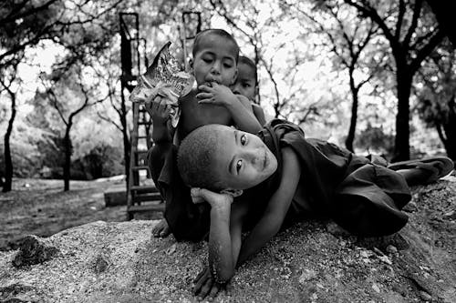 Grayscale Photo of Three Children Near Trees