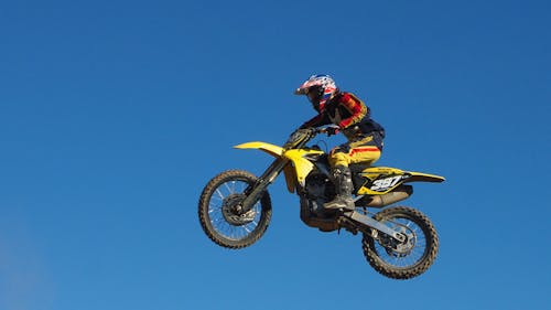 Mann, Der Gelbes Motocross Dirt Bike Reitet