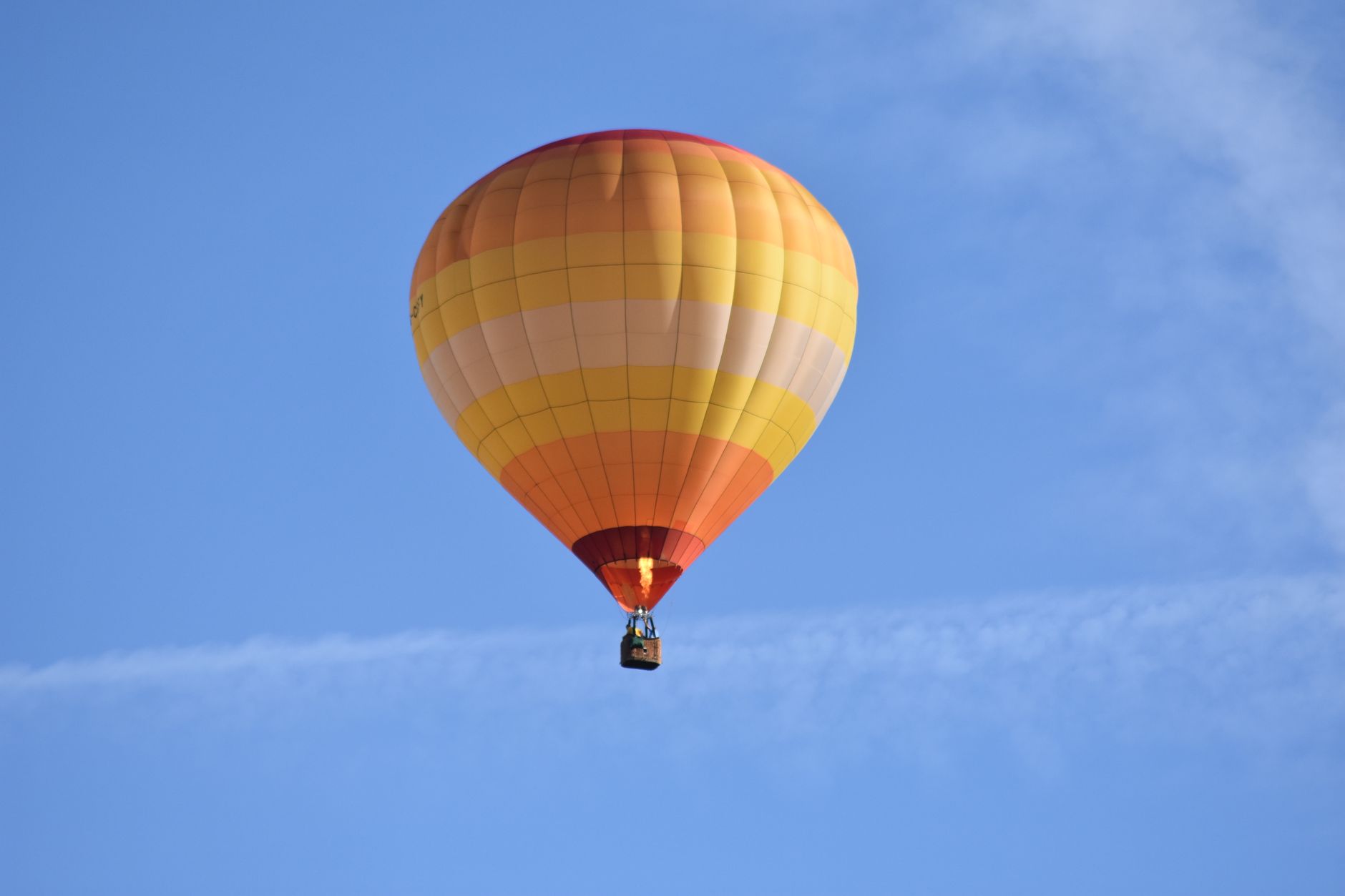 Vibrant hot air balloon soaring high in a clear blue sky, capturing adventure and freedom.
