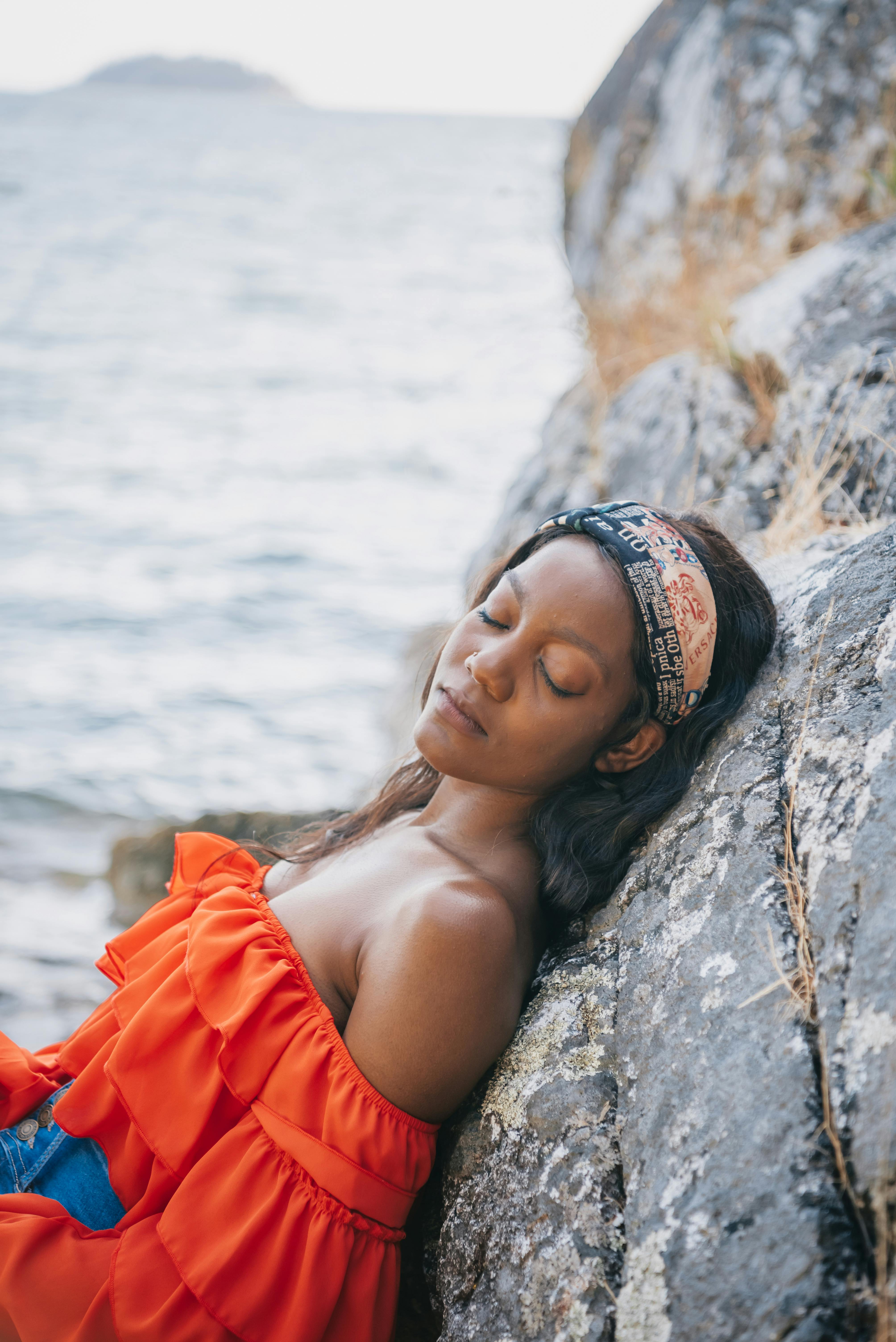 woman leaning on gray rock