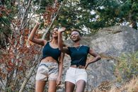 Woman in Black Tank Top and White Shorts Sitting on Brown Tree Branch