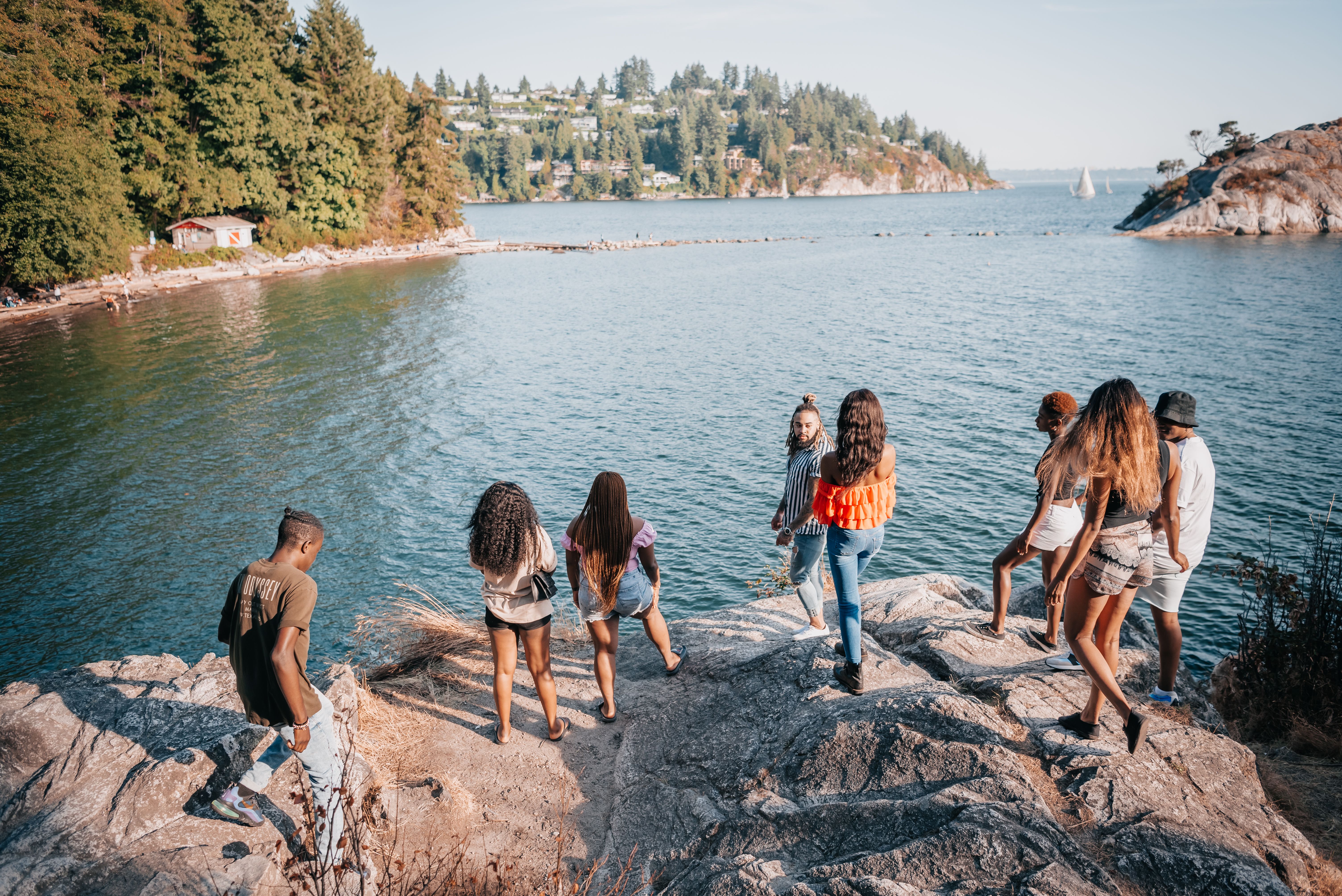 Group of People Standing on Big Rocks Beside a Riveer · Free Stock Photo