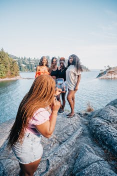 A group of friends enjoying a day by the lake, capturing memories. Perfect for travel or lifestyle motifs.