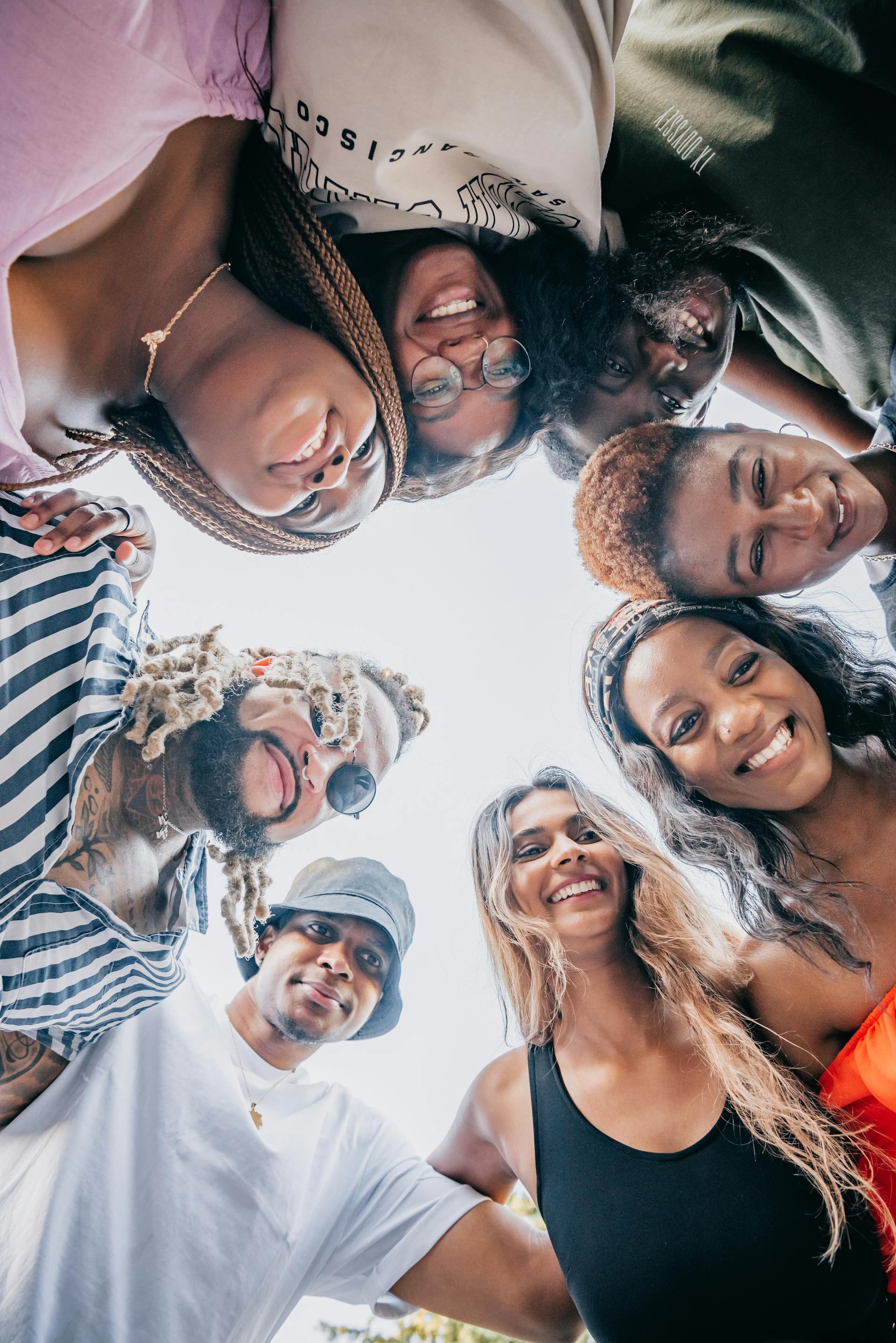 A happy and diverse group of friends pose together outdoors, looking cheerful
