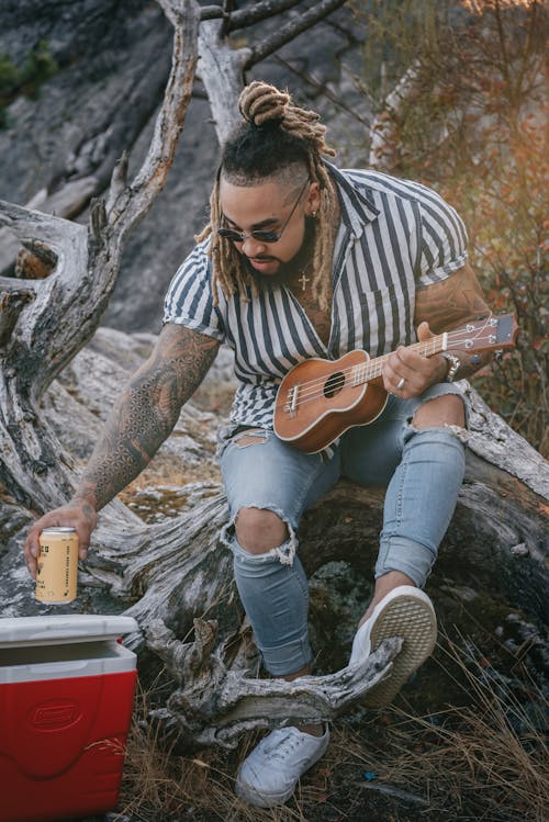 Man with Ukulele Holding Canned Beverage