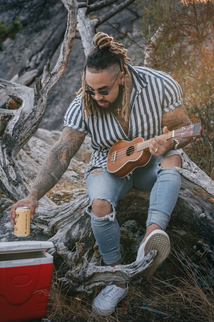 Man With Ukulele Holding Canned Beverage