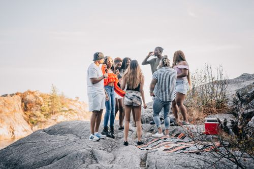 Free A group of young adults socializing and drinking on a rocky outdoor location. Stock Photo