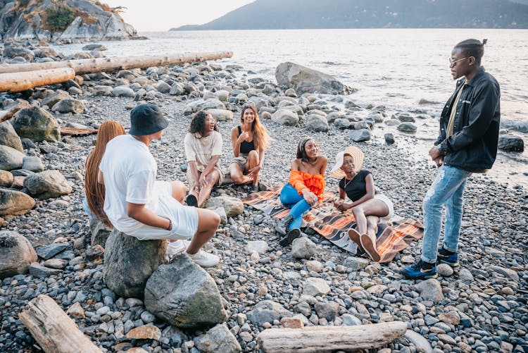 Group Of People Hanging Out On Seashore