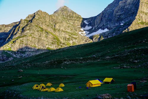 Free Tents on Green Grass Near Rocky Mountains Stock Photo