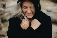 Smiling Woman in Black Long Sleeve Shirt Wearing Black Hat