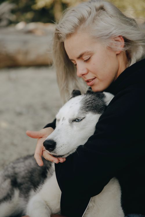 Free Young woman affectionately hugging her husky dog outdoors, showcasing a tender bond. Stock Photo