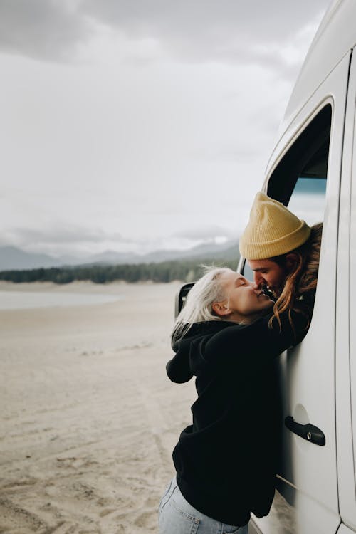 Photo of a Woman Kissing a Man Inside the Van