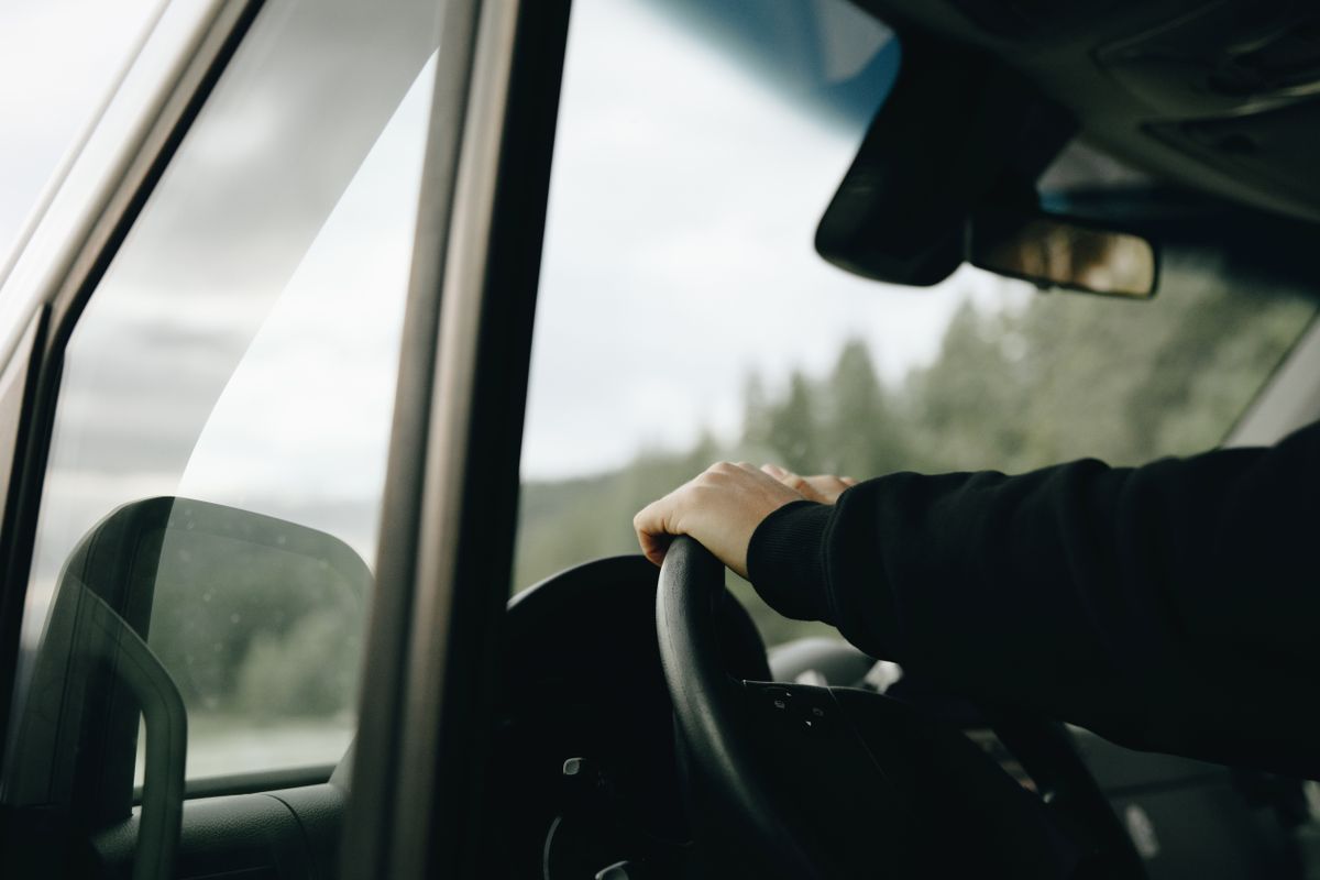 Manos al volante en un camino tranquilo