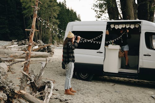 Couple Hanging String Lights Outdoors