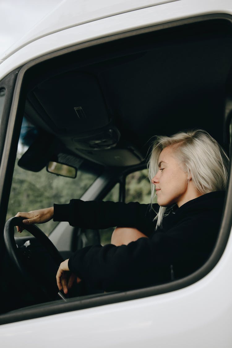 Woman In Black Jacket Driving A Car