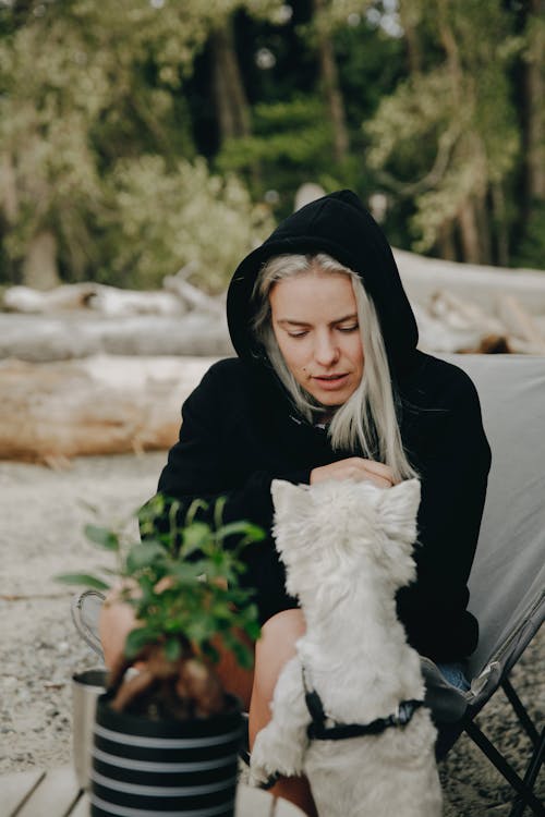 White Dog Standing in Front of a Woman