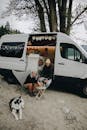 Man and Woman Hanging Out on a Camper Van with a Dog