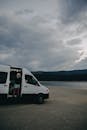 Woman Standing in a Campervan While Looking at the Beach