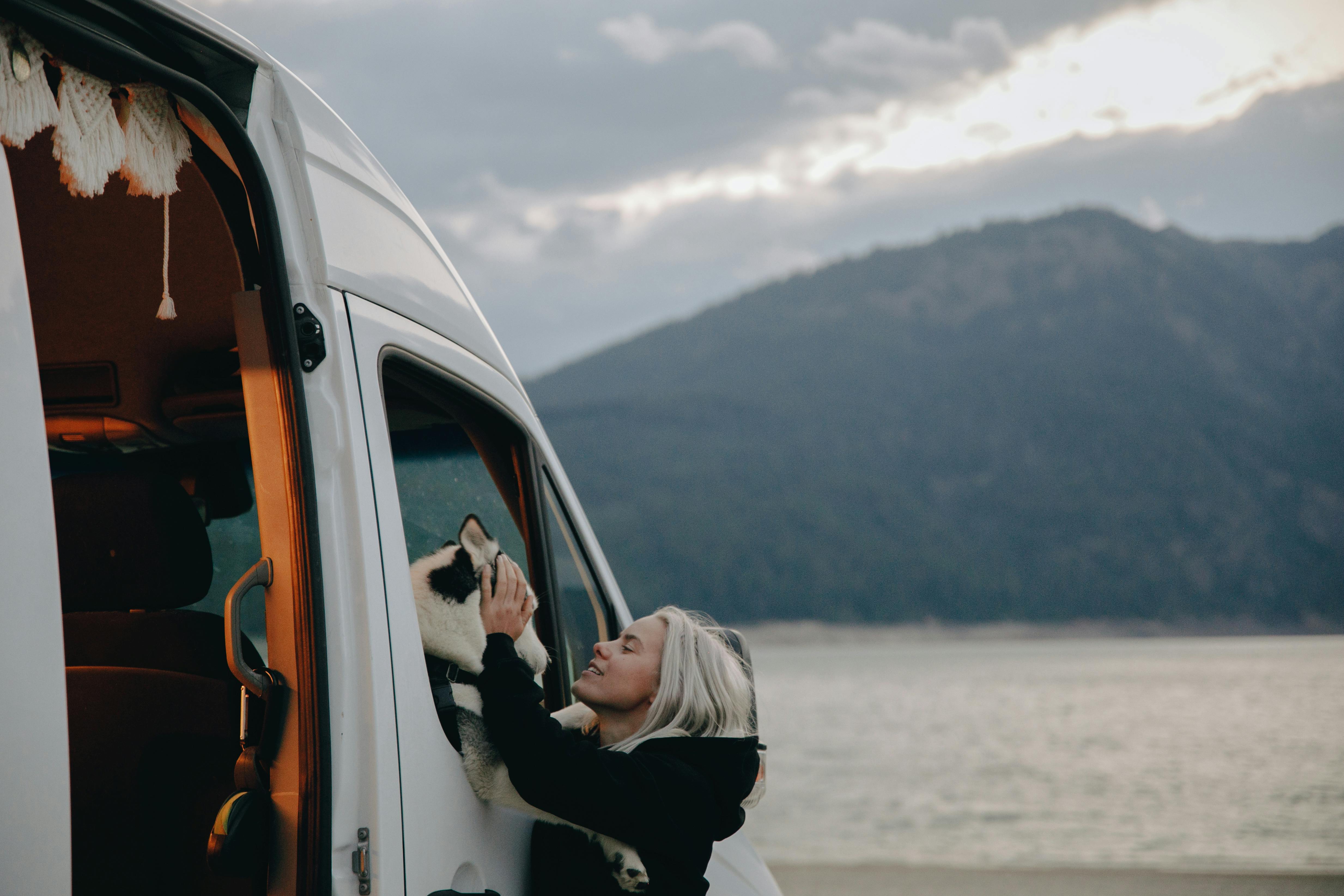 A Woman Petting Her Dog in a Van