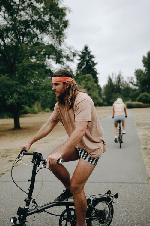 Free Caucasian man cycling on a park path, showcasing outdoor activity and leisure. Stock Photo