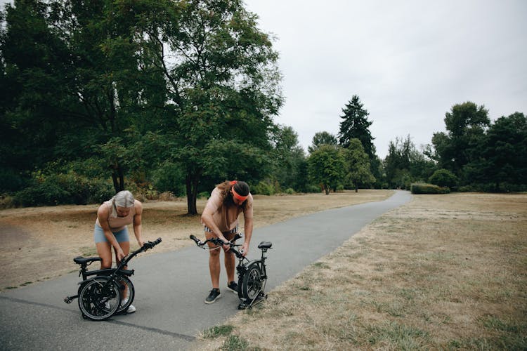 Man And Woman Fixing Their Bicycles