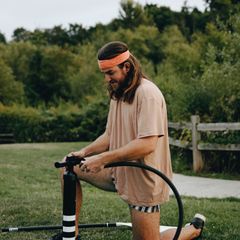 A man using a black floor pump outdoors
