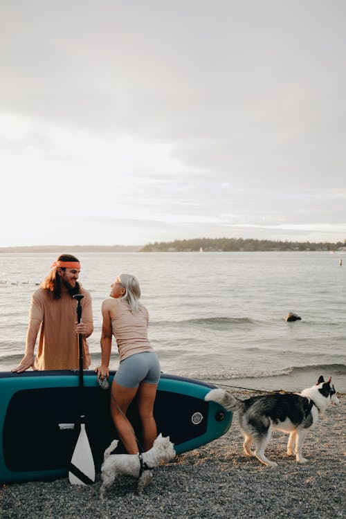 Happy Couple Looking at Each Other while Standing on the Beach