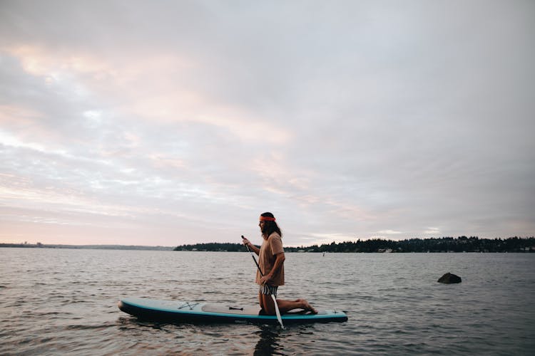 A Woman Sup Boarding On The Lake