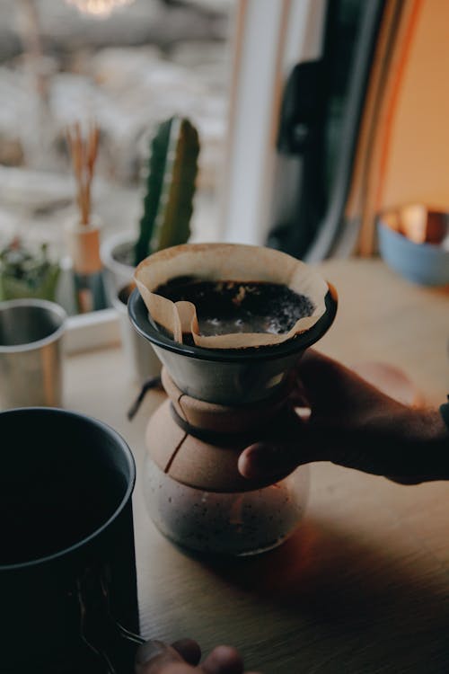 Hand of a Person Holding a Coffee Dripper