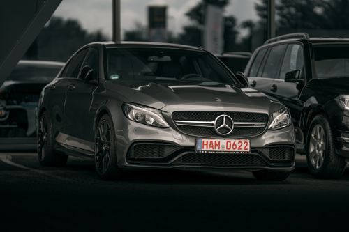 Free Elegant silver luxury car parked in a city setting, showcasing sleek design and modern style. Stock Photo