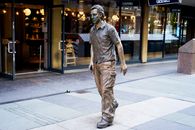 Man in Coat Statue Near Building