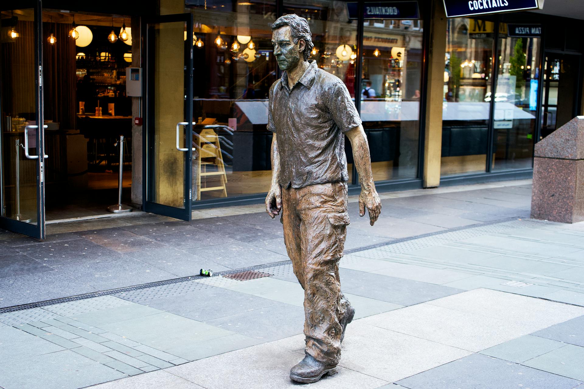 Man in Coat Statue Near Building