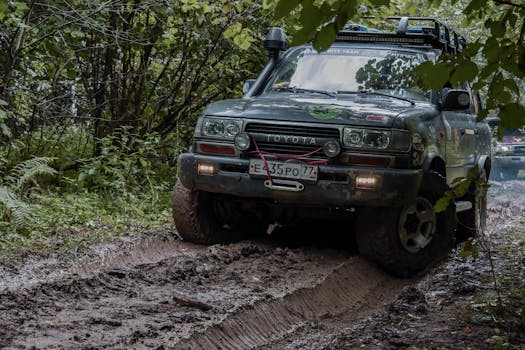 A rugged Toyota navigates a muddy forest trail in Russia, showcasing adventure and durability.