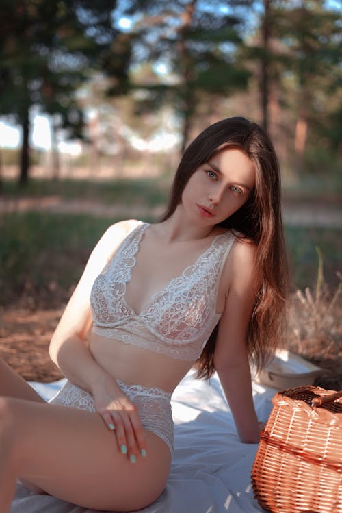 Shallow Focus of a Sexy Woman Wearing White Undergarments while Sitting on Picnic Blanket 